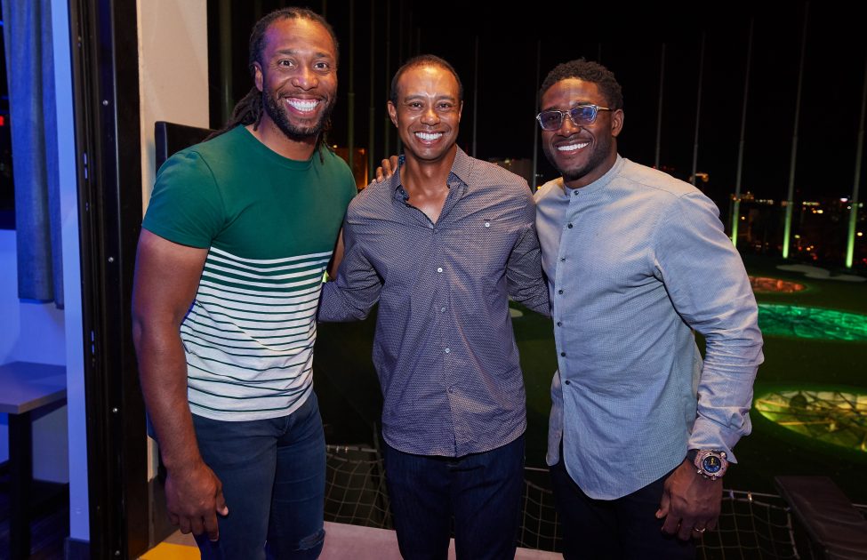Tiger Woods poses with Larry Fitzgerald and Reggie Bush at Topgolf